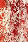 Verblasstes rot-weisses Ornamentmuster an Wand (Ausschnitt)