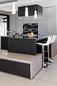 Multifunctional units, breakfast bar with bar stools, integrated, low sideboard and pendant lamps in designer kitchen