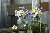 Romantic posies of wild campanula, ox-eye daisies and chamomile in glass vases