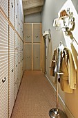Fitted wardrobes and jacket hung on valet stand in narrow dressing room