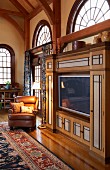 Flatscreen TV integrated into traditional, elegant, country-house interior with arched windows