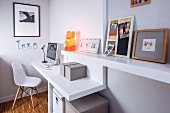 Plastic Chair at small, fitted desk with pictures on integrated floating shelf