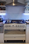 Gas cooker below stainless steel extractor hood integrated into kitchen counter