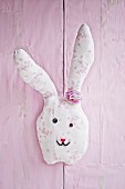 Hand-sewn fabric rabbit on pink wall