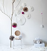 Hand-made, pleated paper stars with cut-out patterns as festive wall decorations