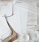 Papiertüten, Muffinförmchen und weiße Blätter als Bastelmaterialien für Weihnachtsdeko