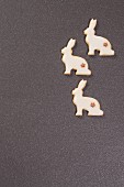 Three festive, rabbit-shaped biscuits on grey surface