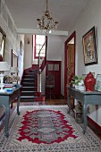 Console tables in foyer of 18th-century, French country house in shades of red and grey