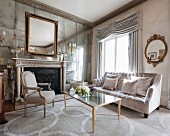 Antique furniture and fireplace in mirrored wall in luxurious interior