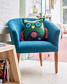 Owl-shaped cushion on blue fifties' armchair