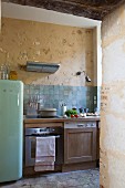 Retro fridge and kitchen counter with wooden cabinets in rustic kitchen