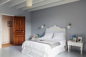 White bed in French bedroom with dove-grey wooden floor and walls