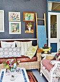 Vintage seating, gallery of pictures on wall and bamboo ladder in living room