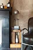 Vintage table lamp on shelf made from wooden crate next to armchair
