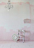 Vintage chair against wall carelessly painted pink and white