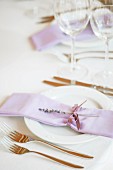 Lilac line napkin with sprig of lavender on festive place setting