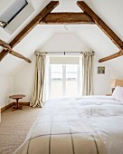 Double bed in bedroom with wood-beamed ceiling