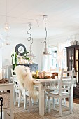 Set dining table and white chairs in cosily lit dining room