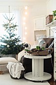 Cable reel used as side table next to armchair and Christmas tree in background