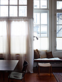 Dining table and bench against wall made from lattice windows