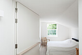 Flexible wall with hinges in bedroom with sloping ceiling