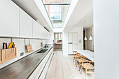 Long kitchen counter and modern skylight in kitchen-dining room