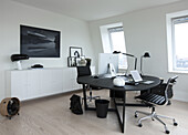 Two work spaces on round table in front of white sideboard