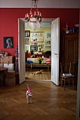 View of sofa and gallery of pictures seen through open double doors in period apartment
