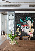 Portrait on modern quilt hung on wall behind wooden dining table