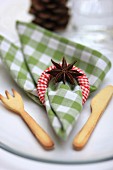 Christmas place setting with linen napkin, napkin ring, star anis and pastry cutlery
