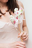 Woman holding floral, fabric love-heart on wooden stick