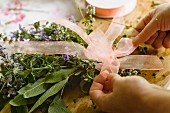 Tying bouquet of herbs with a ribbon