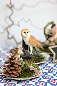 Festive table decorations with pine cones, moss, stars and animal ornaments