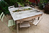 Miniature bed of succulents integrated into rustic wooden table outdoors