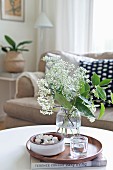 White umbels in glass vase on wooden tray