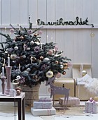 Weihnachtlich dekorierter Raum mit Christbaum, Geschenken & Kerzenleuchtern