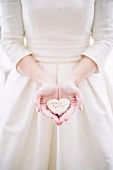 Bride holding heart-shaped wedding pastry