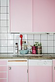Kitchen counter with pink cabinets and concrete worksurface