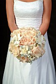 Bride holding bouquet of roses and gardenias