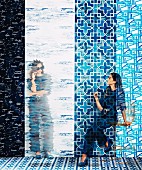 Pattern mix in shades of blue: Young woman in front of different tracks of wallpaper with different graphic motifs