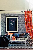 Wohnzimmer mit floralem Mustermix an Tapete, Vorhang, Sofa und Kissen