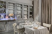 Set Christmas dininer table next to dresser in white shabby-chic interior