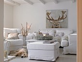 White upholstered furniture, picture of reindeer and dog in wintry living room