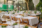 Tables set for summer party in greenhouse