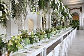 Festive wedding table with green and white flower arrangements in hall