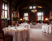 Tables festively set for wedding in interior of Hever Castle, Kent, England