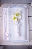 White napkin decorations with Christmas roses and decorative stars