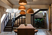 Vintner with wooden counter, bar stools, cork lampshades and steel staircase