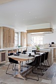 Country-house kitchen with wooden fronts, wooden table and modern chairs