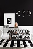Young woman in a black and white living room with graphic patterns